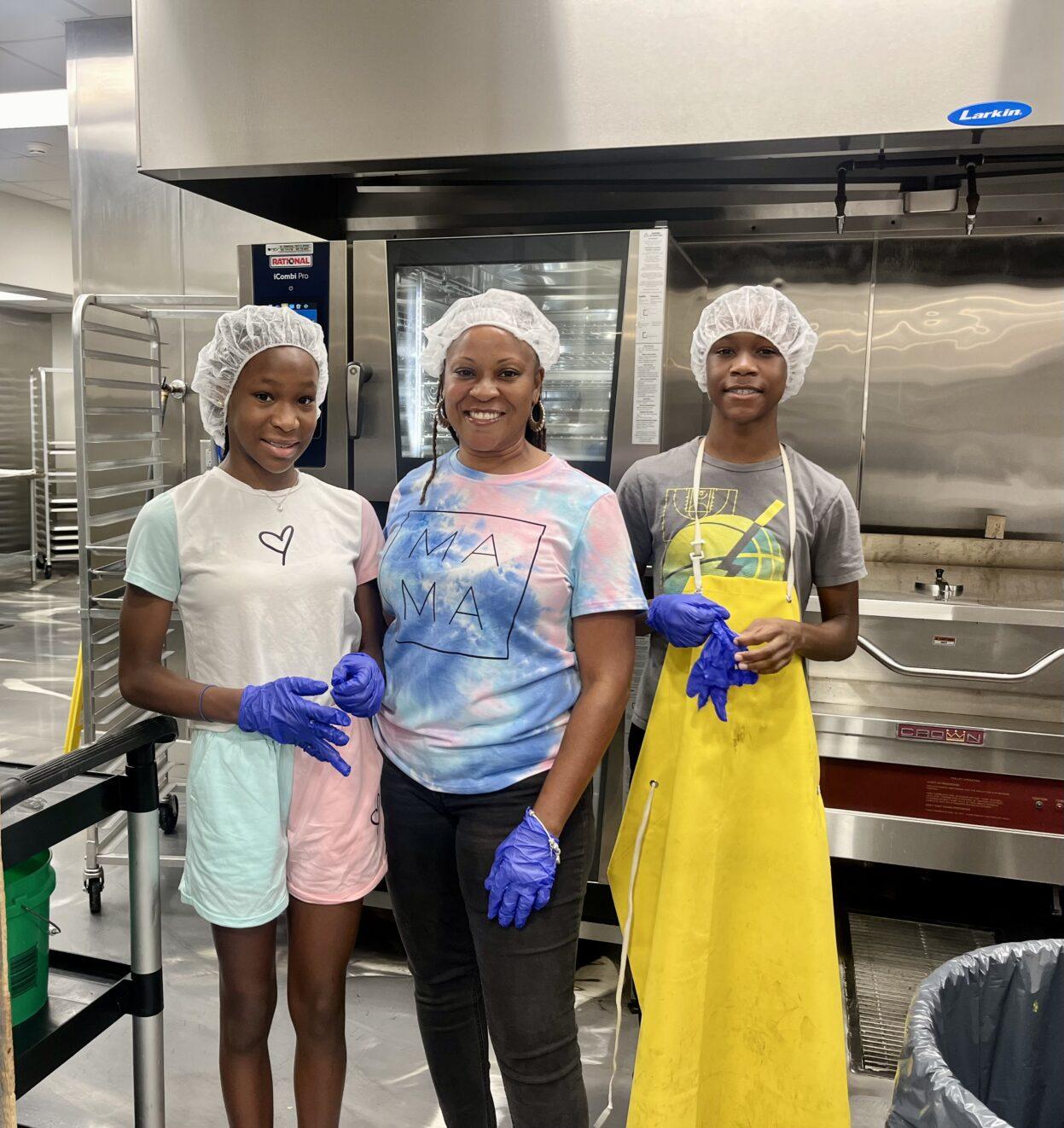 Prielle Lior stands alongside her brother and mother in a kitchen
