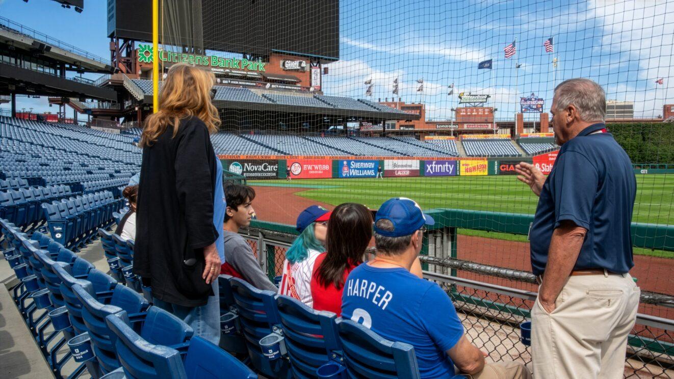 PALCS families sitting in the lower level seating behind protective netting watching players take batting practice on the field at Citizens Bank Park.