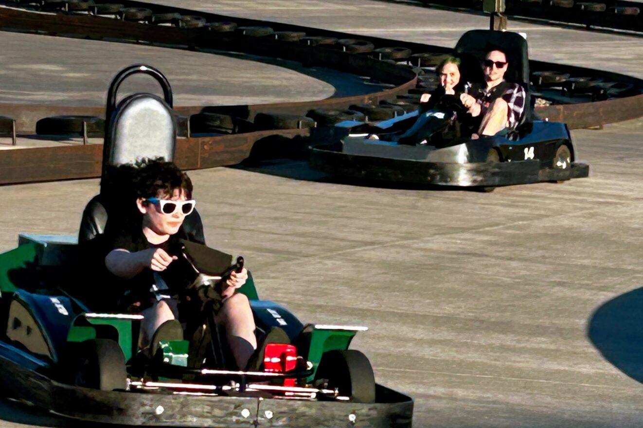 A child steering a green go-kart on a outdoor track during the meet and greet at Sunview Golf and Games.