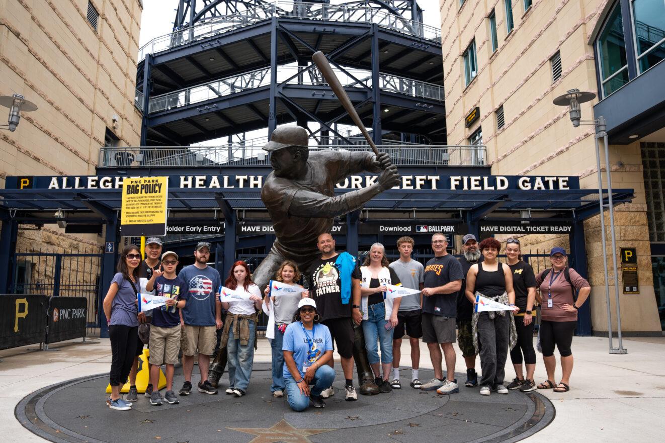 PALCS families post for a picture in front of a statue outside PNC Park.